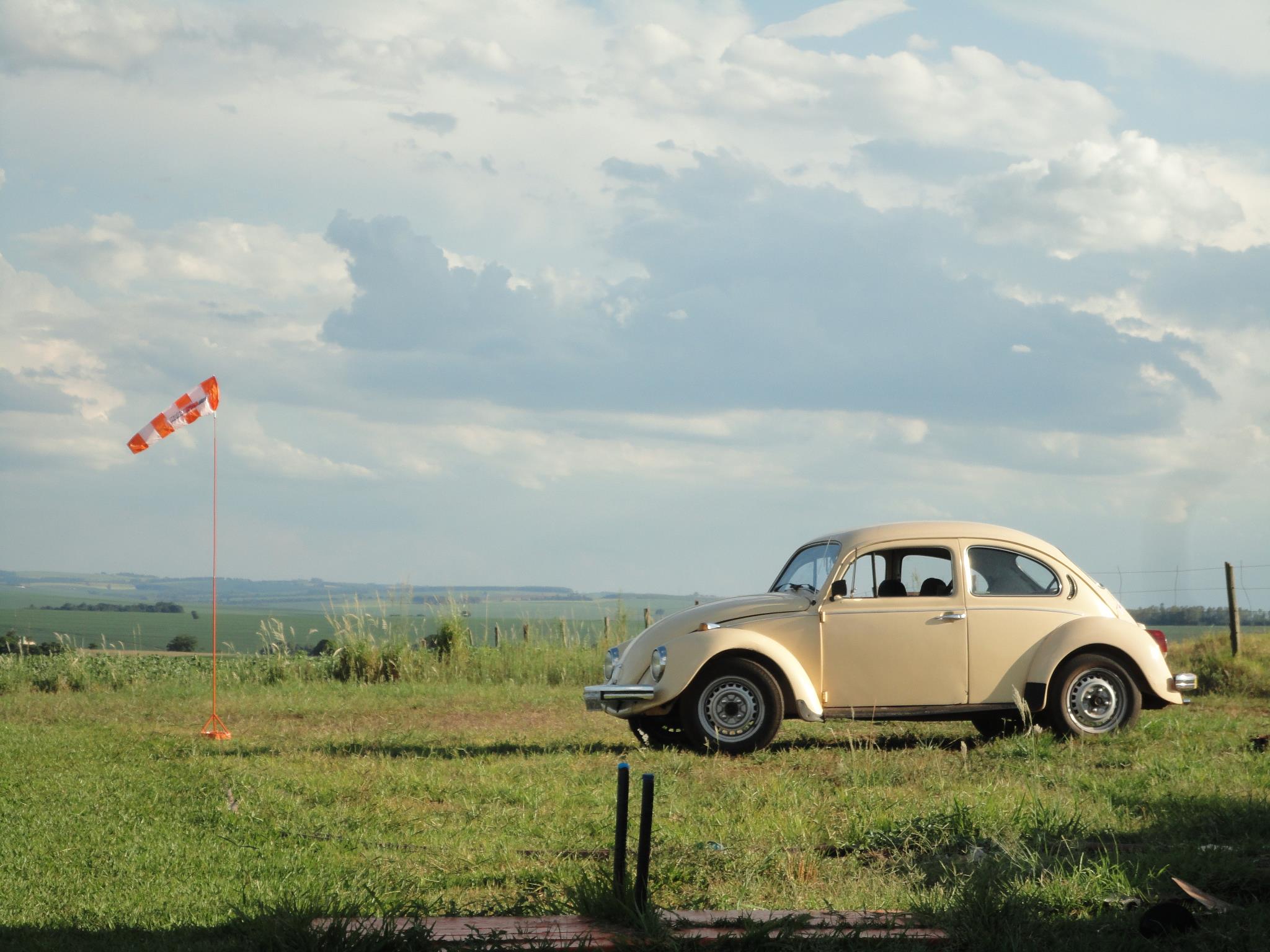 fusca amarelo parado na estrada de terra